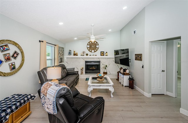 7547 Landmark Dr, Spring Hill, FL 34606 - living room with light wood-type flooring, a ceiling fan, lofted ceiling, recessed lighting, and a fireplace