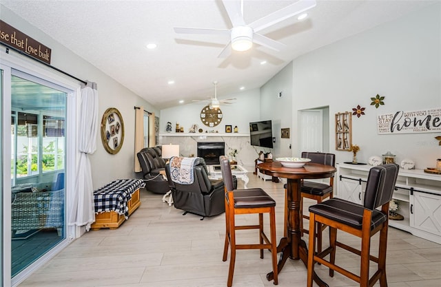7547 Landmark Dr, Spring Hill, FL 34606 - dining space featuring lofted ceiling, ceiling fan, a fireplace, recessed lighting, and light wood-style flooring