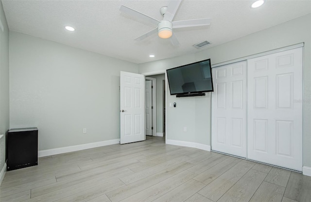 7547 Landmark Dr, Spring Hill, FL 34606 - unfurnished bedroom featuring light wood-type flooring, a closet, a ceiling fan, recessed lighting, and a textured ceiling