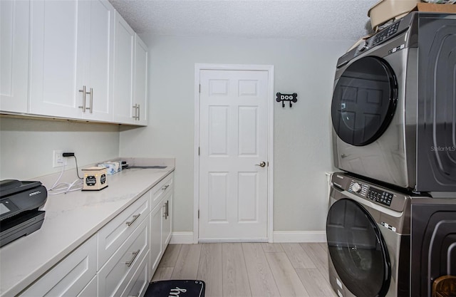 7547 Landmark Dr, Spring Hill, FL 34606 - laundry area featuring estacked washer and dryer, light wood-style flooring, and a textured ceiling