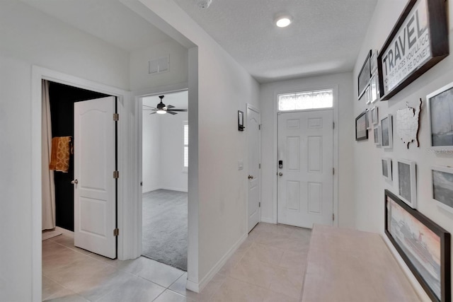3628 Diving Dove Ln, Bartow, FL 33830 - entrance foyer with light tile patterned flooring, a textured ceiling, light carpet, baseboards, and ceiling fan