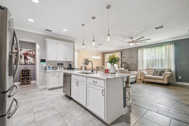 10512 Scenic Hollow Dr, Riverview, FL 33578 - kitchen featuring a sink, stainless steel appliances, ornamental molding, open floor plan, and arched walkways