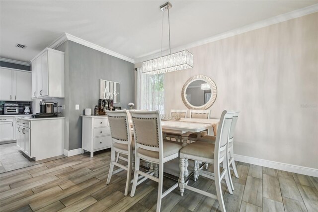 10512 Scenic Hollow Dr, Riverview, FL 33578 - dining room featuring ornamental molding, light wood-type flooring, a chandelier, and baseboards