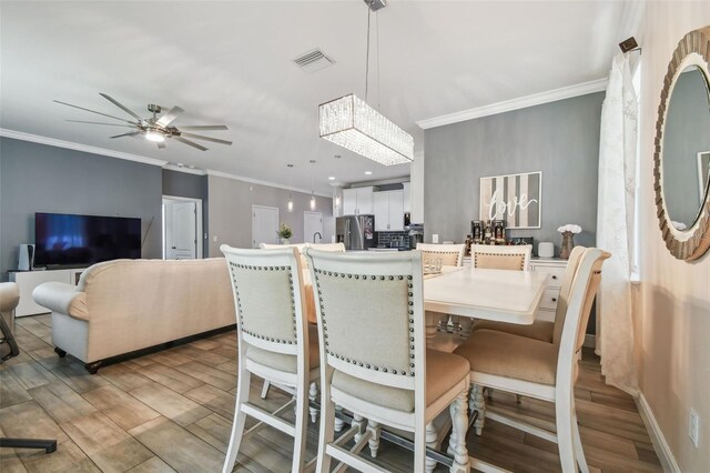 10512 Scenic Hollow Dr, Riverview, FL 33578 - dining area with crown molding, light wood finished floors, ceiling fan, a chandelier, and recessed lighting