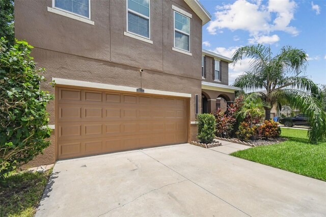 10512 Scenic Hollow Dr, Riverview, FL 33578 - view of front of home with stucco siding, a garage, and driveway