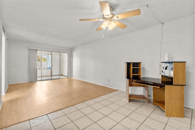4500 E Bay Dr Unit 106, Clearwater, FL 33764 - unfurnished living room featuring a textured ceiling, ceiling fan, and light wood-style flooring