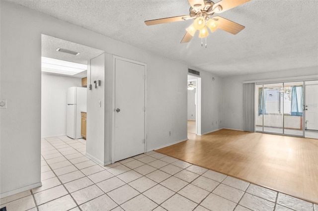 4500 E Bay Dr Unit 106, Clearwater, FL 33764 - spare room featuring a textured ceiling, ceiling fan, light tile patterned flooring, and baseboards
