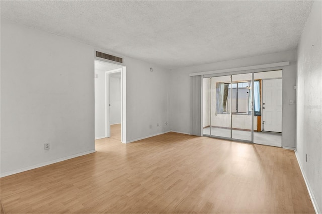 4500 E Bay Dr Unit 106, Clearwater, FL 33764 - spare room with a textured ceiling, light wood finished floors, and baseboards