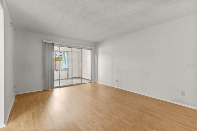 4500 E Bay Dr Unit 106, Clearwater, FL 33764 - spare room featuring a textured ceiling, light wood-style floors, and baseboards