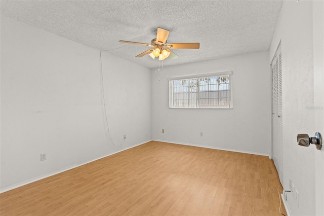 4500 E Bay Dr Unit 106, Clearwater, FL 33764 - empty room featuring ceiling fan, light wood-style flooring, a textured ceiling, and baseboards