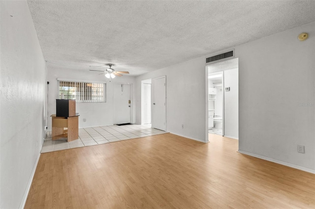 4500 E Bay Dr Unit 106, Clearwater, FL 33764 - unfurnished living room with a ceiling fan, wood finished floors, a textured ceiling, and baseboards