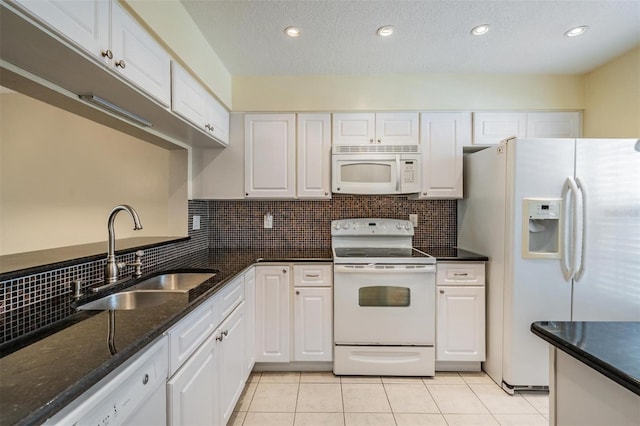 340 Causeway Blvd Unit 105, Dunedin, FL 34698 - kitchen featuring white appliances, a sink, white cabinetry, light tile patterned floors, and decorative backsplash