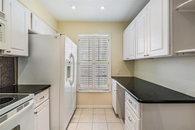340 Causeway Blvd Unit 105, Dunedin, FL 34698 - kitchen with white cabinetry, light tile patterned floors, recessed lighting, and decorative backsplash