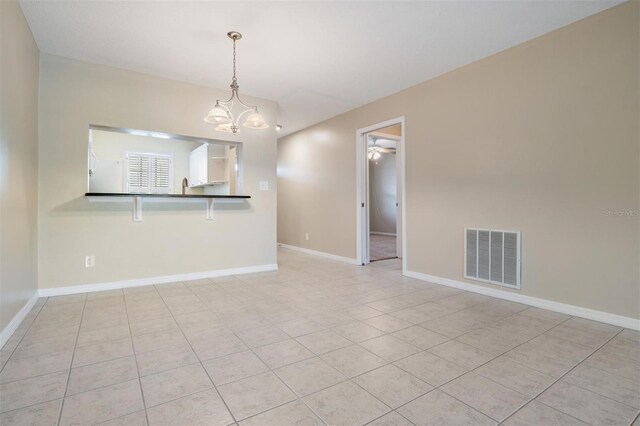 340 Causeway Blvd Unit 105, Dunedin, FL 34698 - spare room with a chandelier, light tile patterned floors, baseboards, and a ceiling fan