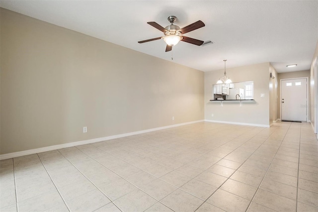 340 Causeway Blvd Unit 105, Dunedin, FL 34698 - unfurnished living room with ceiling fan, a chandelier, light tile patterned floors, and baseboards
