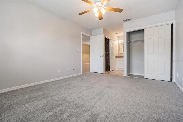 340 Causeway Blvd Unit 105, Dunedin, FL 34698 - unfurnished bedroom with light colored carpet, baseboards, a ceiling fan, and connected bathroom