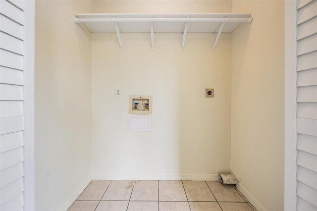 340 Causeway Blvd Unit 105, Dunedin, FL 34698 - washroom with hookup for an electric dryer, washer hookup, light tile patterned floors, and baseboards