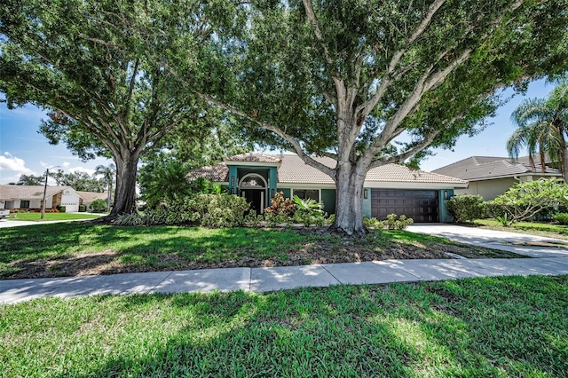 2459 Parkstream Ave, Clearwater, FL 33759 - view of front of house featuring driveway, a tiled roof, a garage, and a front lawn