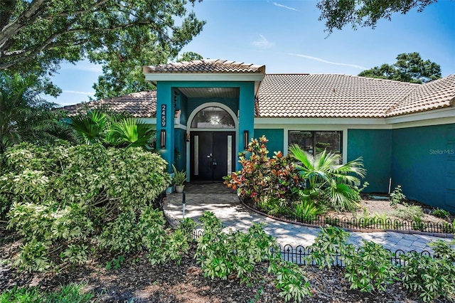 2459 Parkstream Ave, Clearwater, FL 33759 - doorway to property featuring a tiled roof and stucco siding