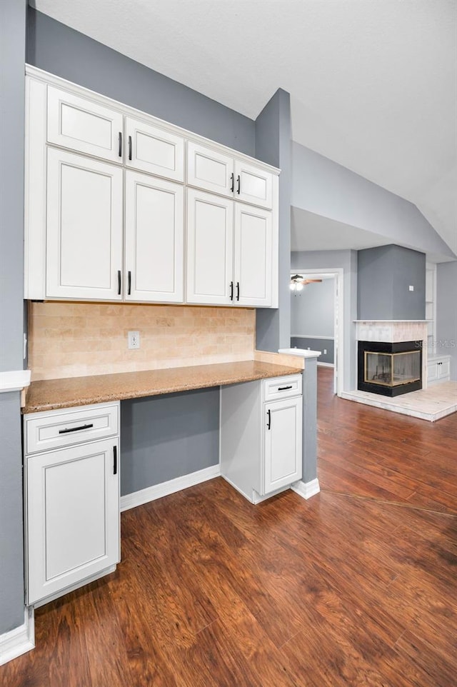 2459 Parkstream Ave, Clearwater, FL 33759 - kitchen featuring tasteful backsplash, white cabinetry, dark wood-type flooring, and lofted ceiling