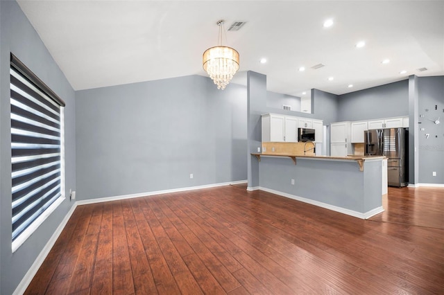 2459 Parkstream Ave, Clearwater, FL 33759 - kitchen featuring stainless steel appliances, a peninsula, a kitchen breakfast bar, dark wood-style floors, and a chandelier