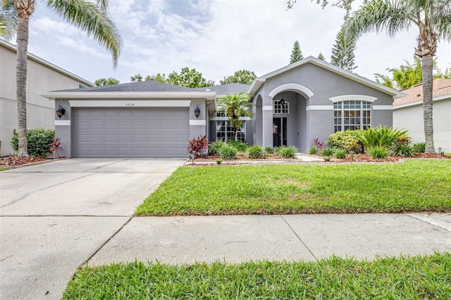 8814 N River Rd, Tampa, FL 33635 - ranch-style house featuring stucco siding, a garage, driveway, and a front yard