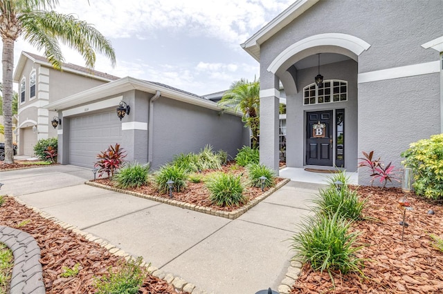 8814 N River Rd, Tampa, FL 33635 - entrance to property featuring stucco siding, a garage, and driveway