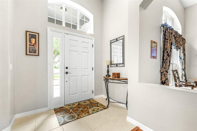 8814 N River Rd, Tampa, FL 33635 - entryway with a towering ceiling, baseboards, light tile patterned floors, and arched walkways