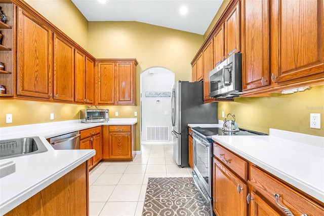 8814 N River Rd, Tampa, FL 33635 - kitchen with stainless steel appliances, open shelves, arched walkways, vaulted ceiling, and light countertops