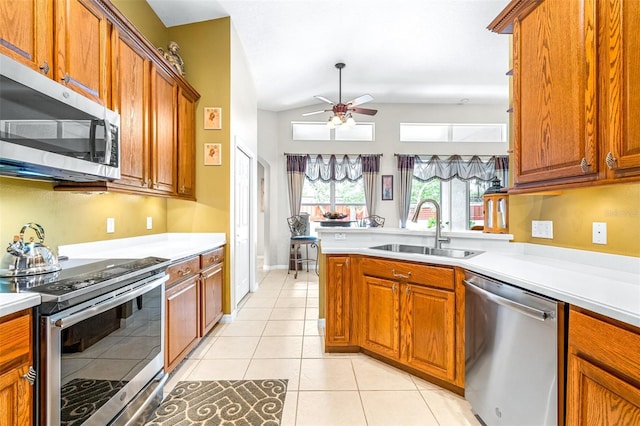 8814 N River Rd, Tampa, FL 33635 - kitchen featuring stainless steel appliances, a sink, a ceiling fan, brown cabinets, and light countertops