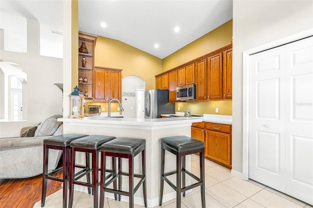 8814 N River Rd, Tampa, FL 33635 - kitchen with appliances with stainless steel finishes, arched walkways, a kitchen bar, a peninsula, and recessed lighting