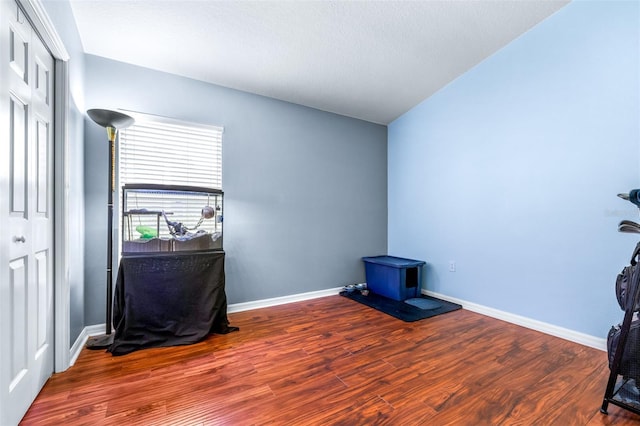 8814 N River Rd, Tampa, FL 33635 - unfurnished office featuring a wood stove, wood finished floors, and baseboards