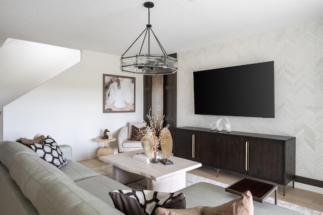 12782 Canter Call Rd, Lithia, FL 33547 - living room with wallpapered walls, a chandelier, an accent wall, light wood-style floors, and baseboards