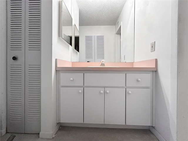 650 Island Way Unit 408, Clearwater Beach, FL 33767 - bathroom featuring a closet, vanity, and a textured ceiling