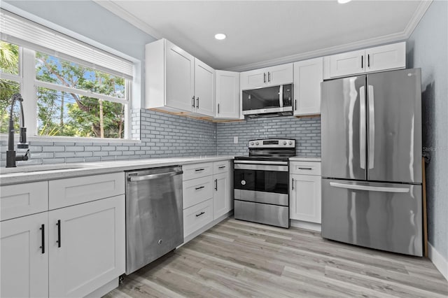 4841 Drift Tide Dr, New Port Richey, FL 34652 - kitchen featuring stainless steel appliances, light countertops, crown molding, decorative backsplash, and white cabinetry