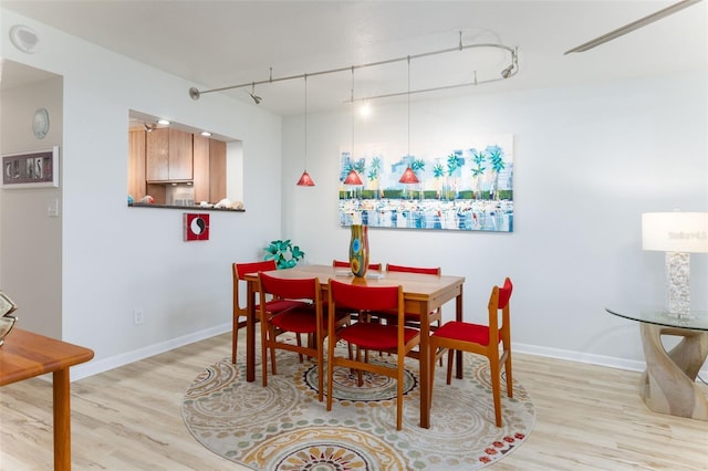 9525 Blind Pass Rd Unit 505, St Pete Beach, FL 33706 - dining space with rail lighting, light wood finished floors, and baseboards