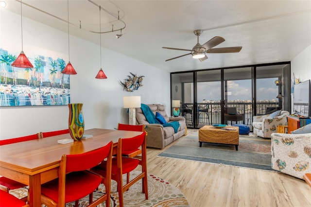 9525 Blind Pass Rd Unit 505, St Pete Beach, FL 33706 - dining space featuring floor to ceiling windows, ceiling fan, and wood finished floors
