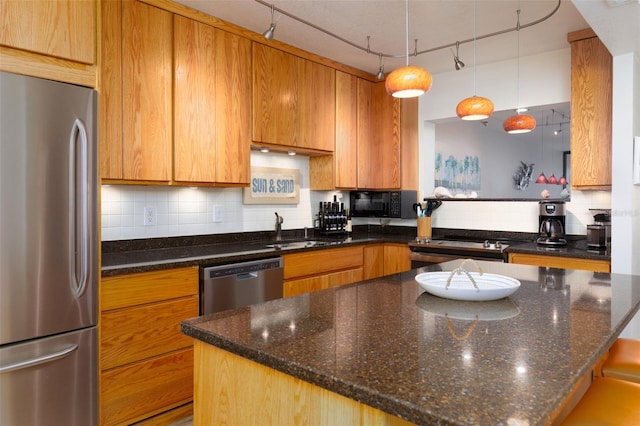 9525 Blind Pass Rd Unit 505, St Pete Beach, FL 33706 - kitchen featuring appliances with stainless steel finishes, a sink, backsplash, and brown cabinets