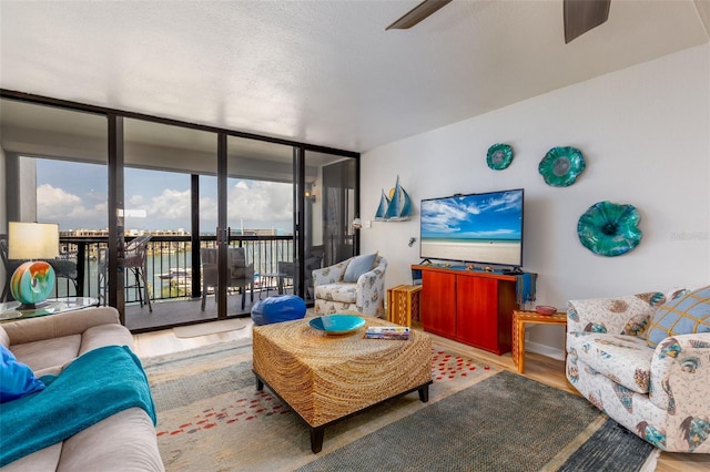 9525 Blind Pass Rd Unit 505, St Pete Beach, FL 33706 - living room featuring floor to ceiling windows, wood finished floors, and a ceiling fan