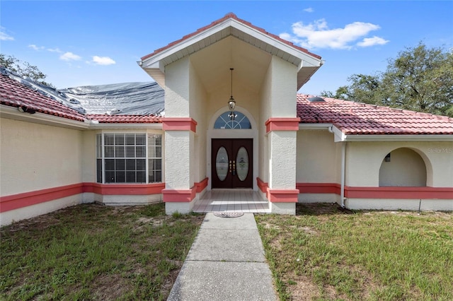 10446 Baylor Dr, Spring Hill, FL 34608 - property entrance featuring a tile roof, stucco siding, and a lawn