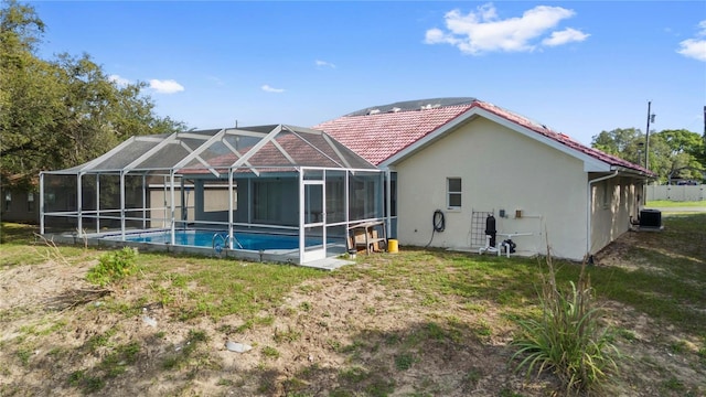 10446 Baylor Dr, Spring Hill, FL 34608 - back of property with stucco siding, a tiled roof, an outdoor pool, central air condition unit, and glass enclosure