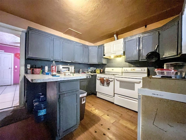 14210 Downing St, Dover, FL 33527 - kitchen featuring white appliances, a peninsula, light countertops, light wood-type flooring, and a textured ceiling