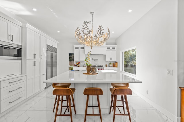 208 Live Oak Ln, Largo, FL 33770 - kitchen featuring stainless steel built in refrigerator, light marble finish floors, glass insert cabinets, a kitchen breakfast bar, and recessed lighting