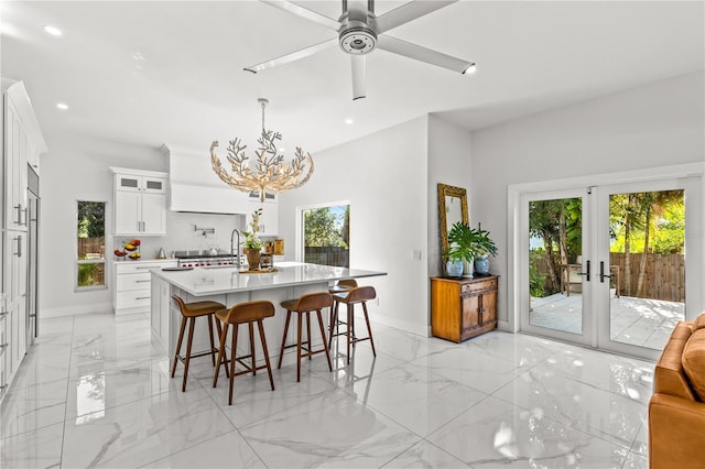 208 Live Oak Ln, Largo, FL 33770 - dining area featuring light marble finish flooring, a chandelier, recessed lighting, a ceiling fan, and french doors