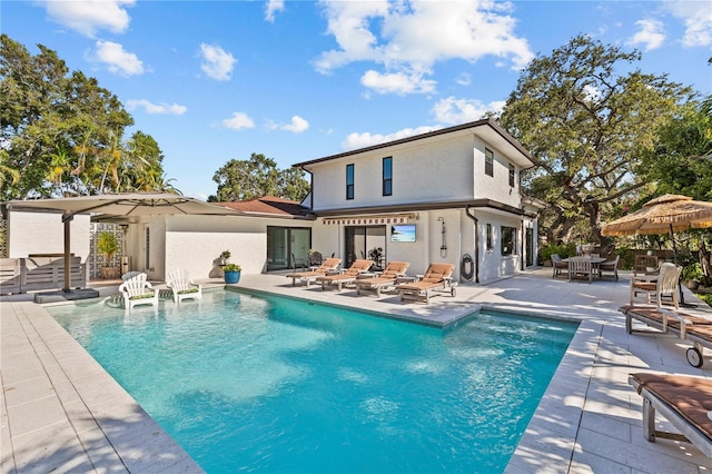 208 Live Oak Ln, Largo, FL 33770 - rear view of house featuring stucco siding, a patio area, and an outdoor pool