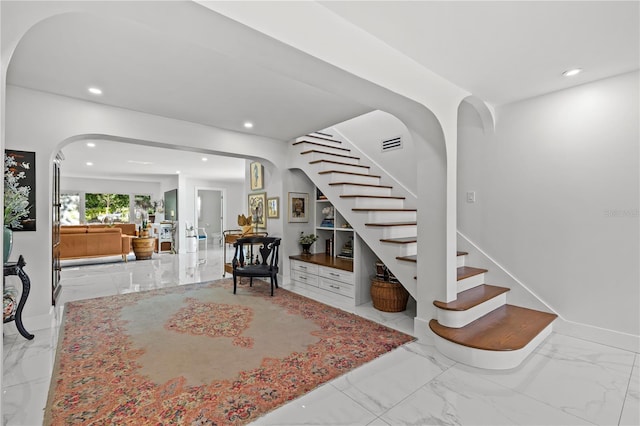 208 Live Oak Ln, Largo, FL 33770 - staircase with arched walkways, marble finish floors, and recessed lighting