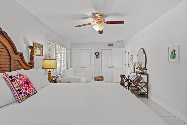 208 Live Oak Ln, Largo, FL 33770 - bedroom featuring two closets, a ceiling fan, and light marble finish floors
