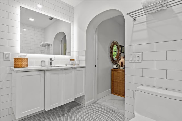 208 Live Oak Ln, Largo, FL 33770 - bathroom featuring tile walls, vanity, and marble finish floors