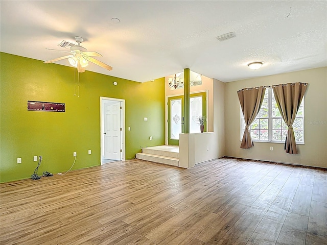 1332 Osceola Hollow Rd, Odessa, FL 33556 - unfurnished living room featuring wood finished floors, a ceiling fan, a chandelier, and a textured ceiling