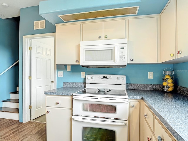 1332 Osceola Hollow Rd, Odessa, FL 33556 - kitchen with white appliances, light wood-style flooring, and cream cabinets
